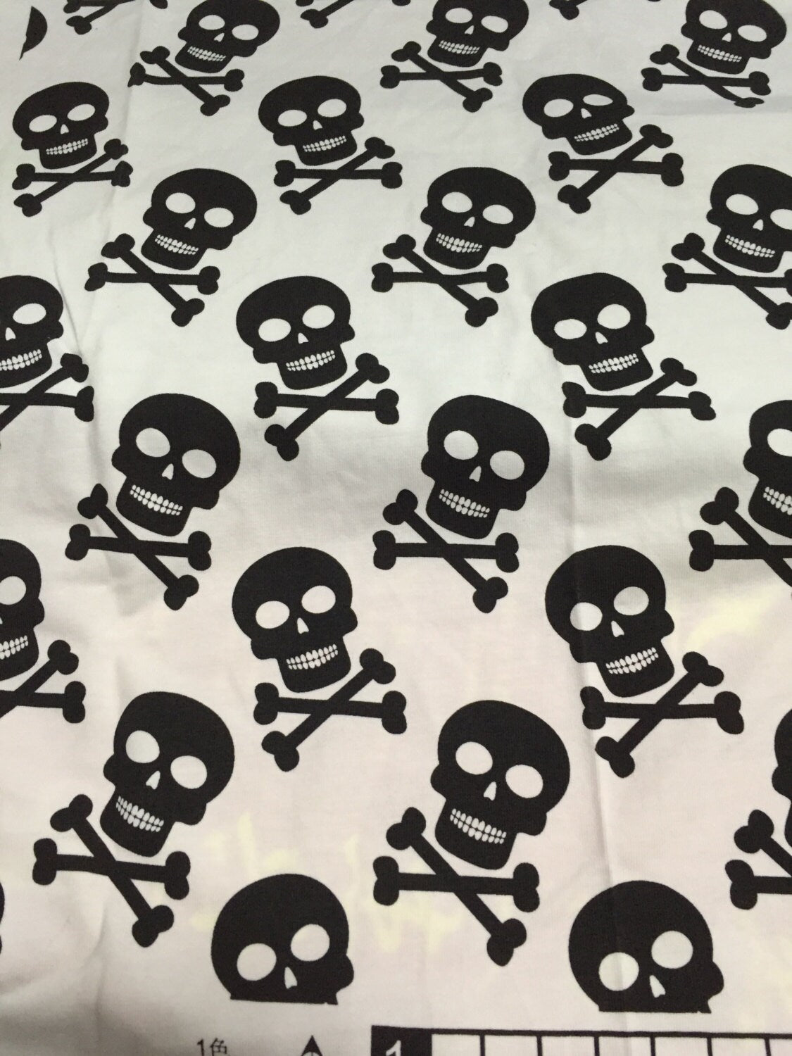 Black Skulls on White Cotton Lycra Fabric